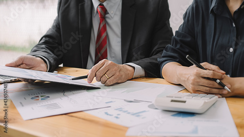 Senior businessman analyzing marketing data staff people discuss work plan pointing at papers at group meeting