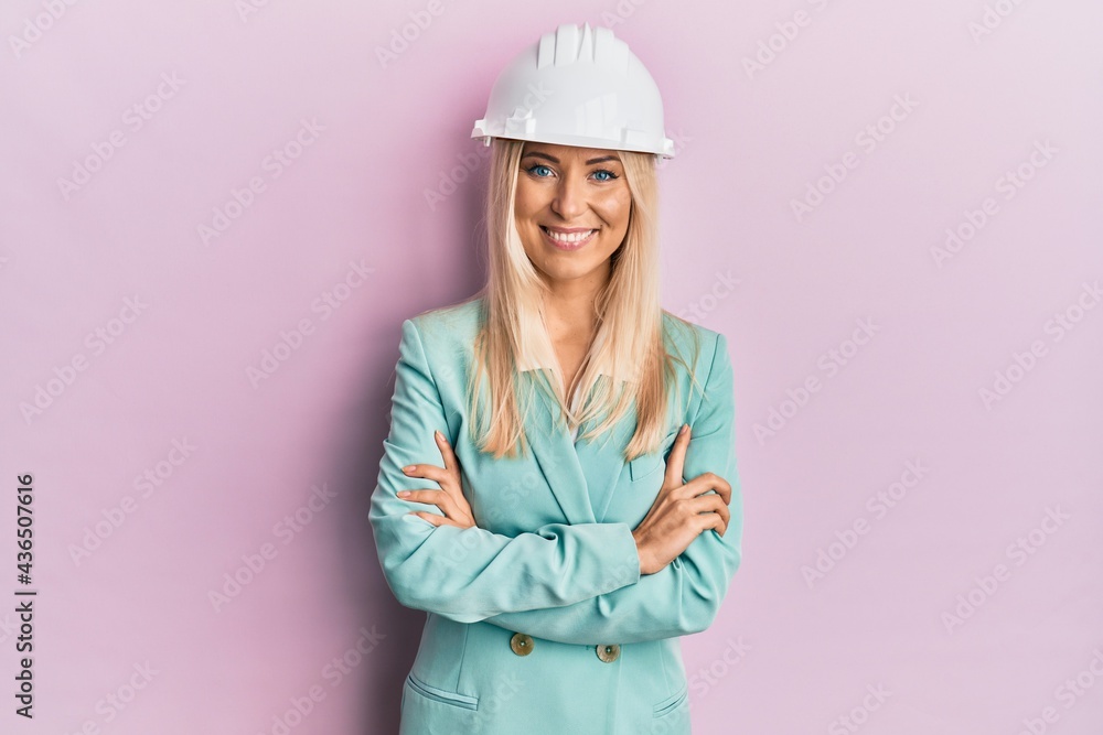 Young blonde woman wearing architect hardhat smiling with a happy and cool smile on face. showing teeth. Young blonde woman wearing architect hardhat smiling with a happy and cool smile on face. showing teeth.