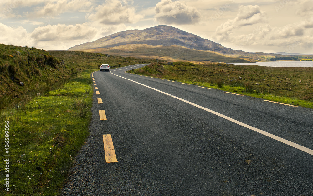 Beautiful scenery of road by the lough inagh with mountains in the background at Connemara National park in county Galway, Ireland Beautiful scenery of road by the lough inagh with mountains in the background at Connemara National park in county Galway, Ireland