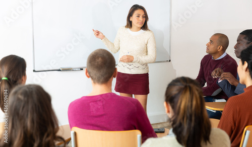 Adult lecturer talking to students during seminar