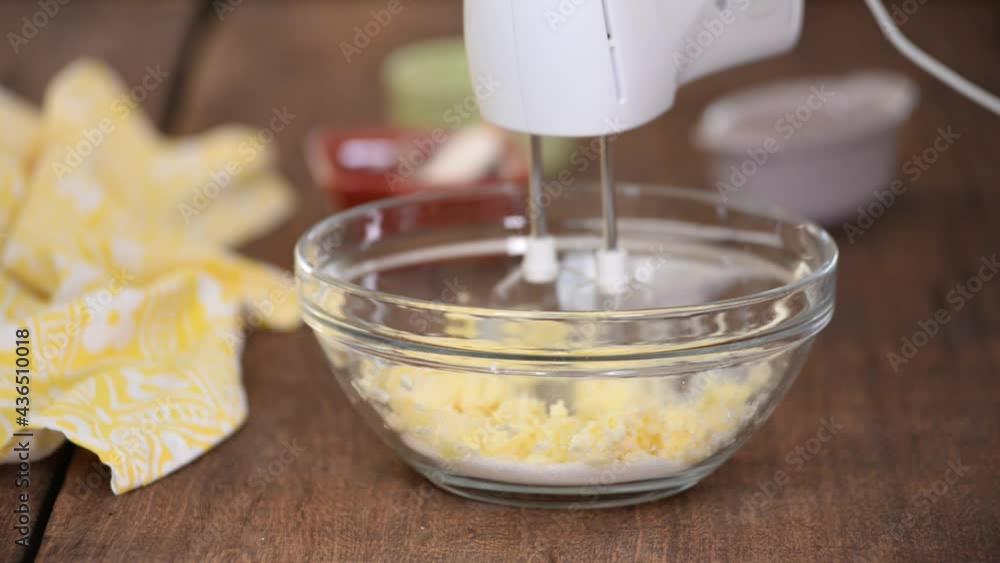 Mixing sugar and butter in a glass bowl. Mixing sugar and butter in a glass bowl.