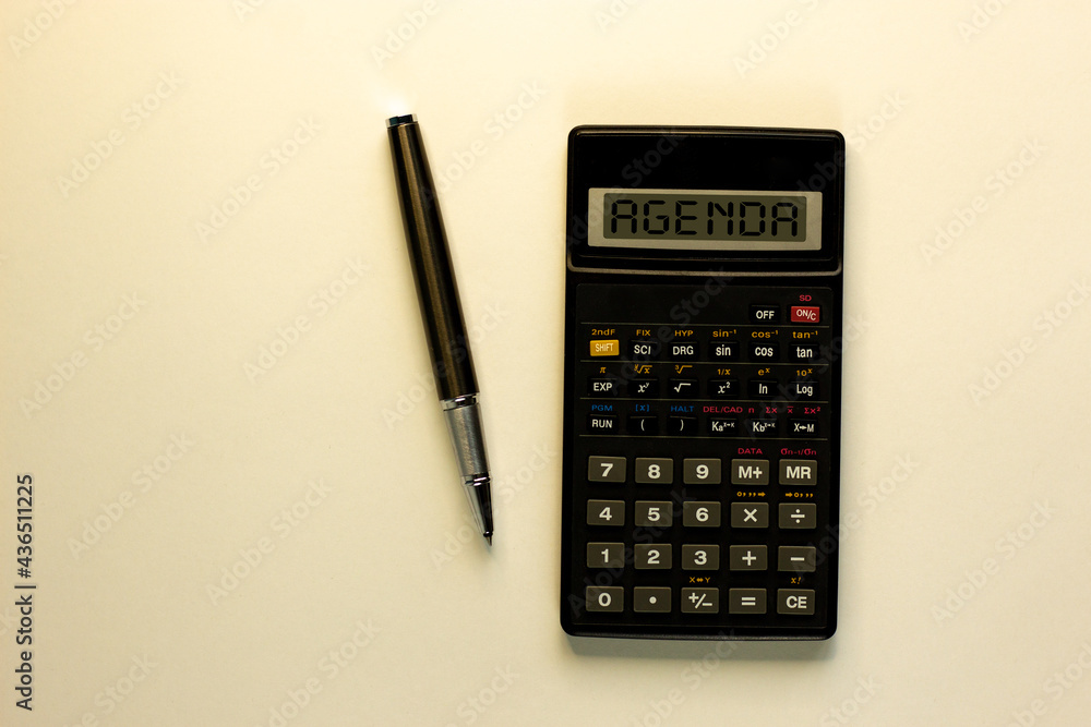 Agenda symbol. Calculator with the concept word 'agenda', metalic pen. Business and agenda concept. Beautiful white background, copy space. Agenda symbol. Calculator with the concept word 'agenda', metalic pen. Business and agenda concept. Beautiful white background, copy space.