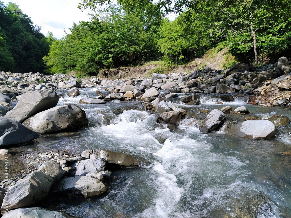 Beautiful nature scenery with green mountains and mountain river. Mountain river with rocks and green forest Beautiful nature scenery with green mountains and mountain river. Mountain river with rocks and green forest