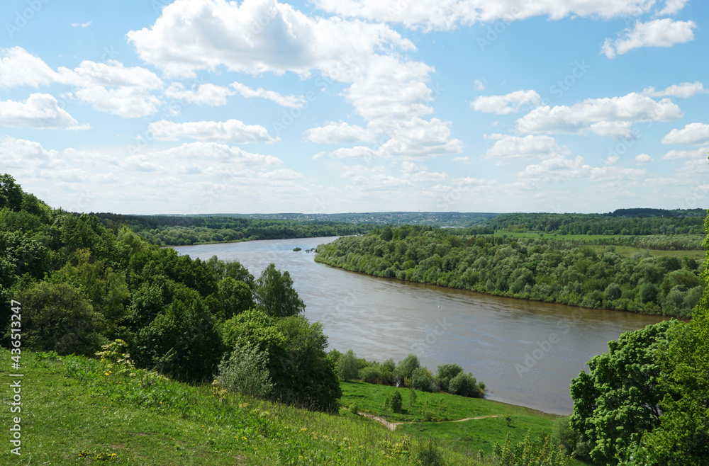 A picturesque view of the bend of the Oka River from a high wooded hill. Windy, sunny summer day.