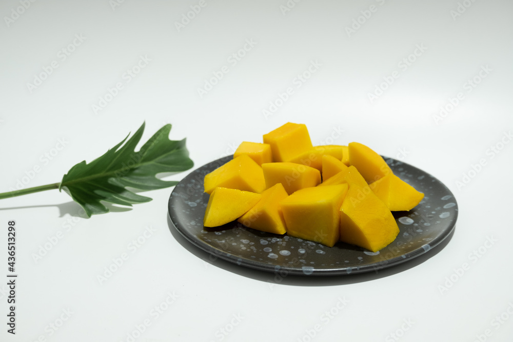 Ripe mangos in a black ceramic dish. Ripe mangos in a black ceramic dish.