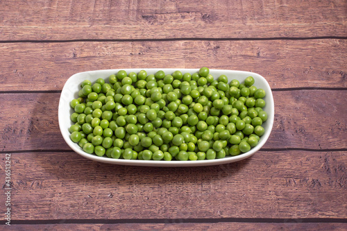 peeled green peas in a white crockery dish ready to cook © josemanuel246
