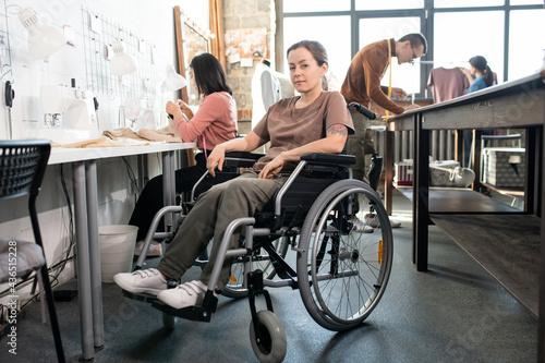 Young female tailor in wheelchair in working environment © pressmaster