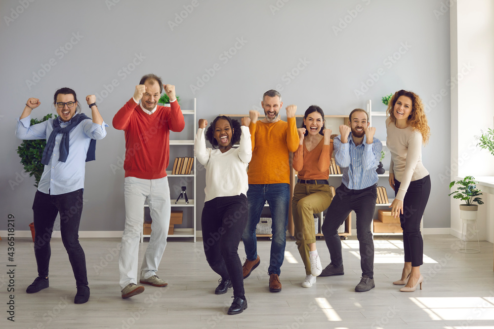 Fototapeta premium Yes. We did it. Team of happy diverse business people celebrating success. Group of coworkers cheering, fist pumping and having fun in modern office excited about successful deal or project completion
