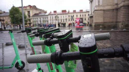 Electric scooters for rent parked in a row in the city. Ecological transportation. Using an electric scooter to get around the city.