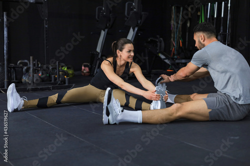 Portrait of a muscular couple doing leg stretchings