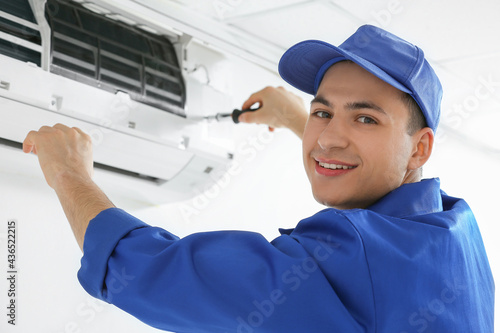 Young electrician repairing...