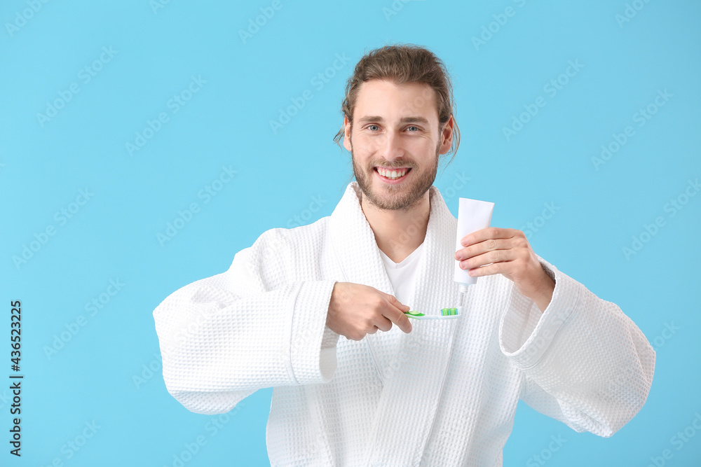 Young man brushing teeth on color background Young man brushing teeth on color background