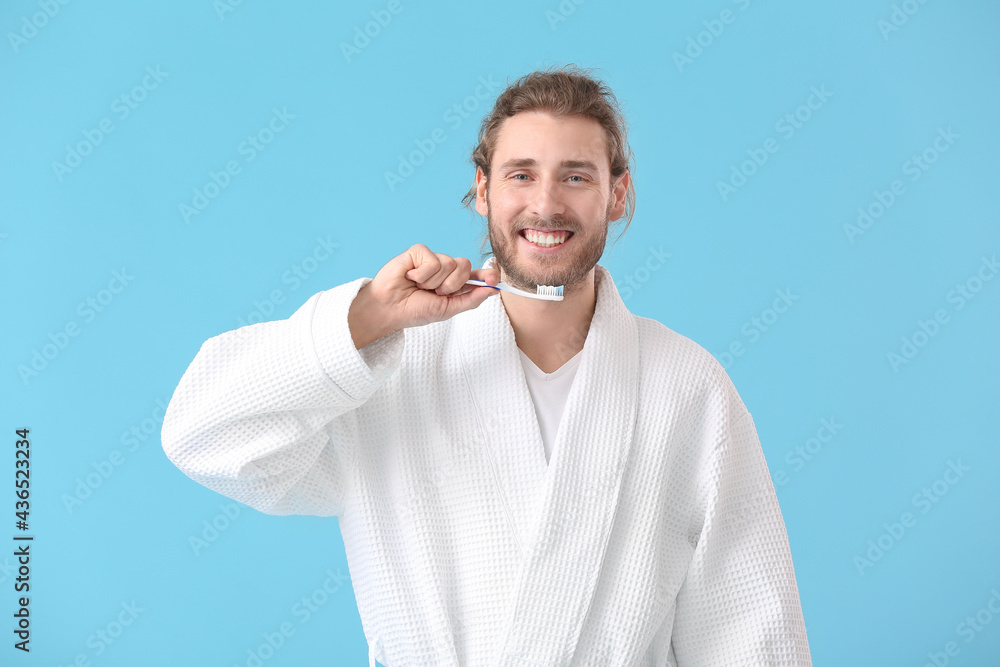 Young man brushing teeth on color background Young man brushing teeth on color background