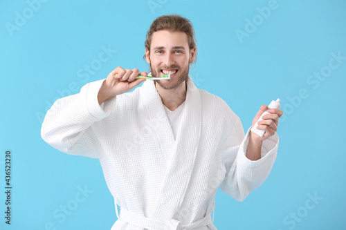 Young man brushing teeth on...