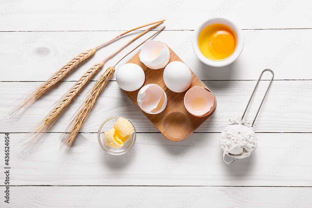 Composition with fresh dough, flour and eggs on light wooden background Composition with fresh dough, flour and eggs on light wooden background