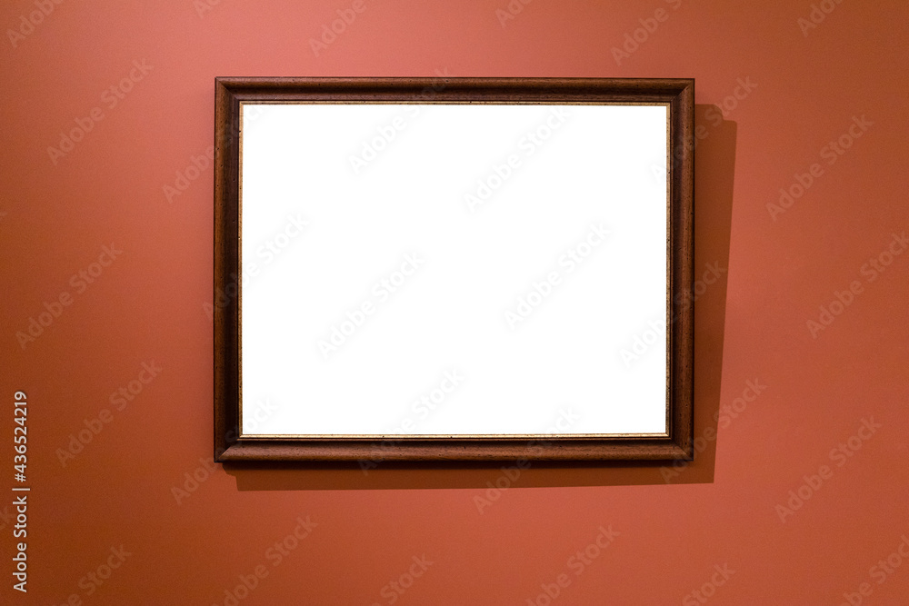 narrow brown wooden picture frame on dark red wall narrow brown wooden picture frame on dark red wall