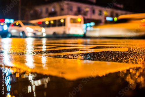 Rainy night in the big city. View of the crossroads at the level of the pedestrian crossing