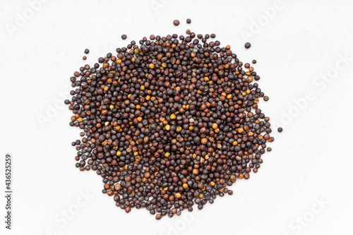 pile of whole-grain rapeseeds close up on gray