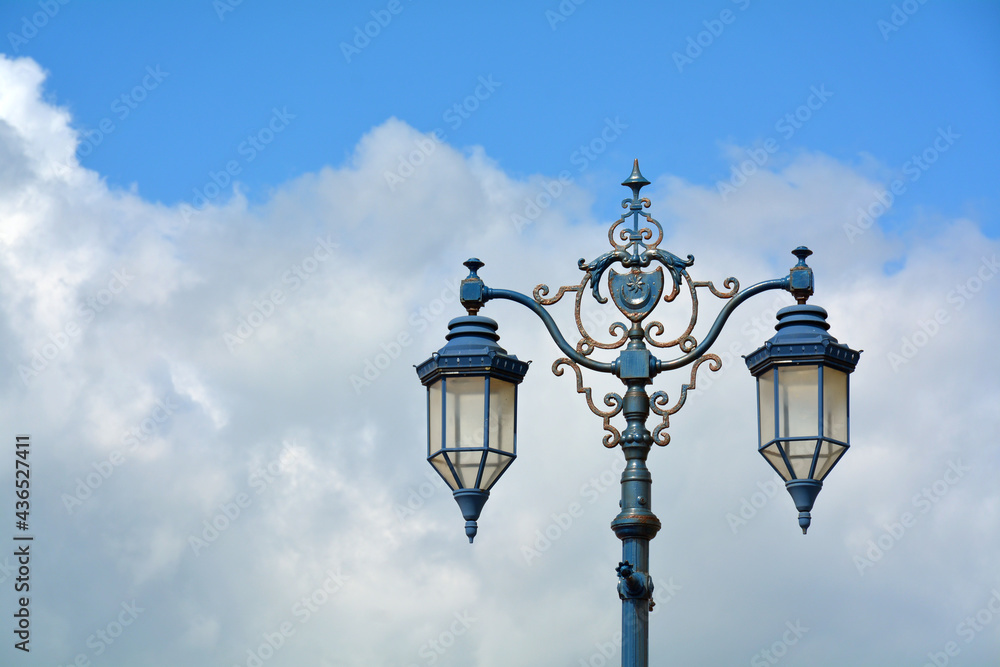 Old style street lamps against a cloudy sky