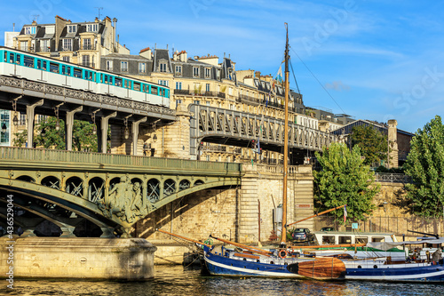 View of the Pont de Bir-Hakeim from the Ile aux Cygnes. Sailboat and buildings of Paris are visible in the background. Paris, France photo