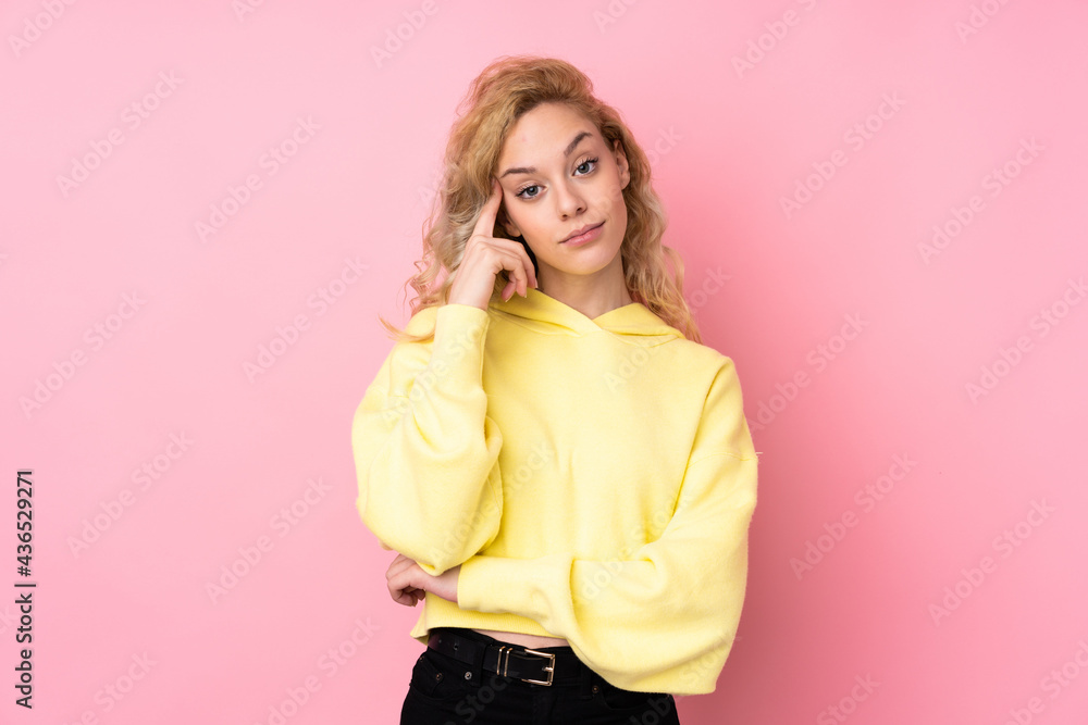 Young blonde woman wearing a sweatshirt isolated on pink background thinking an idea Young blonde woman wearing a sweatshirt isolated on pink background thinking an idea