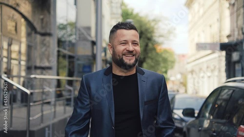 Wallpaper Mural Successful young businessman walk down the street, caucasian man walking along the road outdoors. on background cars are passing by. Handsome man smiling. Torontodigital.ca