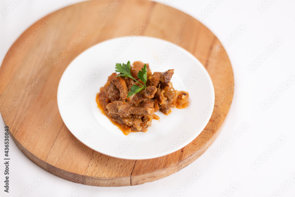 Beef stroganoff garnished with parsley on a white background Beef stroganoff garnished with parsley on a white background