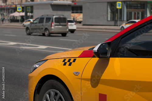 Yellow taxi with checker pattern  close-up view. Yellow taxi cab on the street of downtown