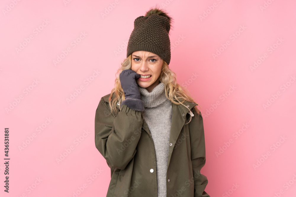 Young girl with winter hat isolated on pink background nervous and scared Young girl with winter hat isolated on pink background nervous and scared