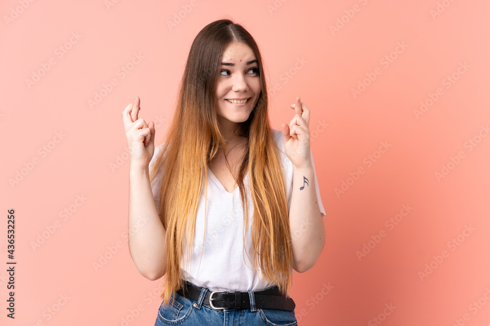 Young caucasian woman isolated on pink background with fingers crossing Young caucasian woman isolated on pink background with fingers crossing
