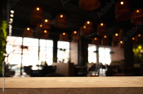 empty wooden table on blurred light gold bokeh of cafe restaurant window on dark background  place for your products on the table
