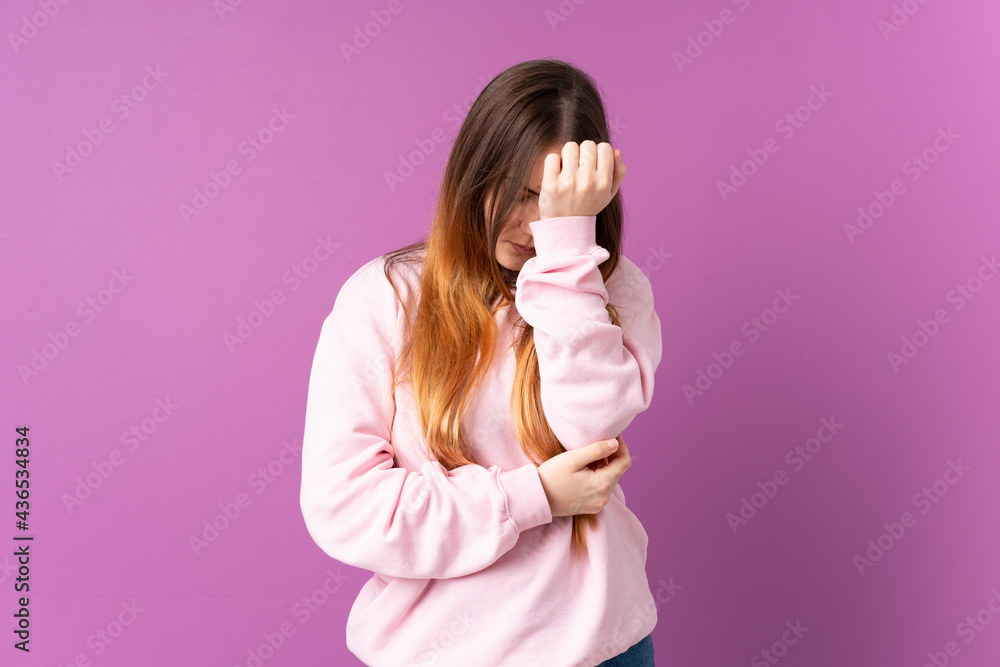 Young caucasian woman isolated on purple background with headache