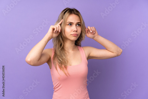 Teenager Russian girl isolated on purple background having doubts and thinking