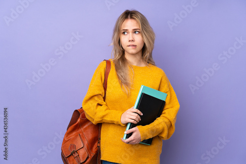 Teenager Russian student girl isolated on purple background with confuse face expression