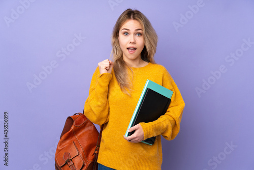 Teenager Russian student girl isolated on purple background celebrating a victory in winner position
