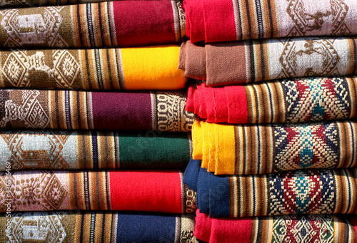 Close-up of colorful blankets folded and arranged on top of each other. Flea market in Jujuy. Argentine North. native motifs. street sale. rustic blanket.