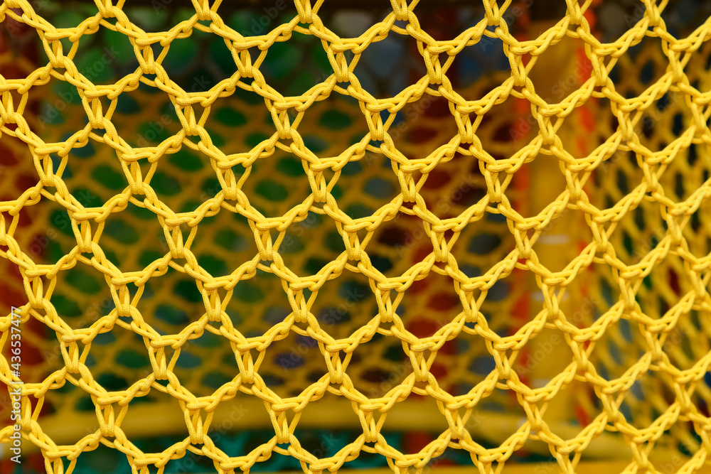 A yellow rope net with a blurred background on the playground. A yellow rope net with a blurred background on the playground.
