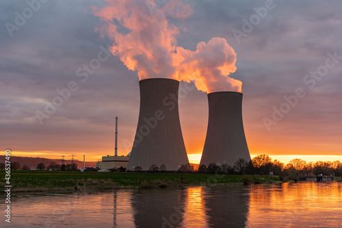 Nuclear power plant against sky by the river at sunset photo