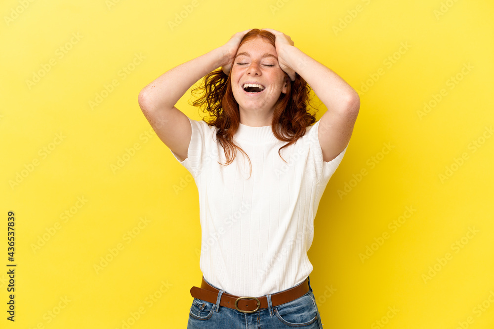 Teenager reddish woman isolated on yellow background laughing Teenager reddish woman isolated on yellow background laughing