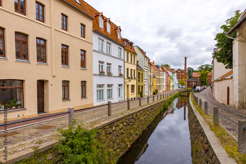 Wismar old town. Colorful houses along the canal of Grube river, Wismar city, Mecklenburg-Vorpommern state, Germany. Cloudy summer day