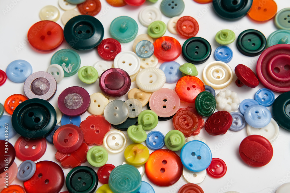 old plastic buttons in different colors on the background. old plastic buttons in different colors on the background.