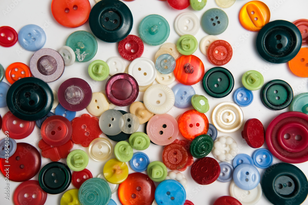 old plastic buttons in different colors on the background. old plastic buttons in different colors on the background.