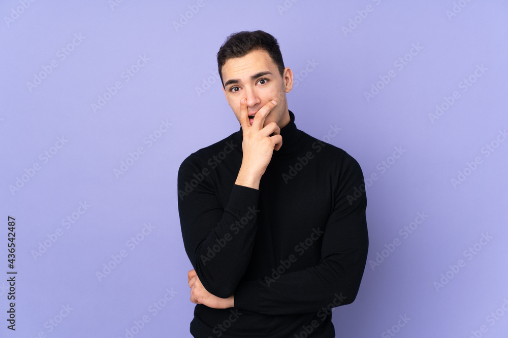 Young caucasian handsome man with turtleneck sweater isolated on purple background surprised and shocked while looking right Young caucasian handsome man with turtleneck sweater isolated on purple background surprised and shocked while looking right