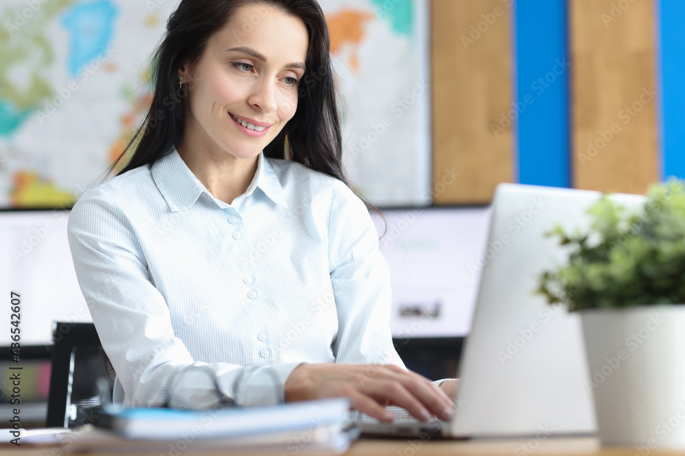 Young smiling woman working on laptop closeup Young smiling woman working on laptop closeup