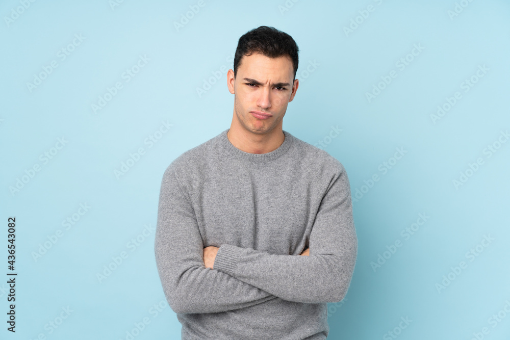 Young caucasian handsome man isolated on blue background sad Young caucasian handsome man isolated on blue background sad