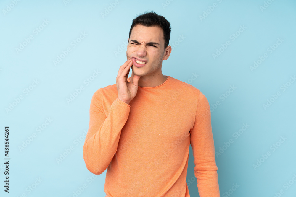Young caucasian handsome man isolated on blue background with toothache Young caucasian handsome man isolated on blue background with toothache