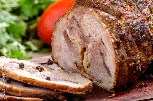 Roasted beef with some slices on a wooden table