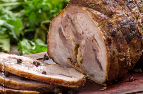 Roasted beef with some silices on a wooden table