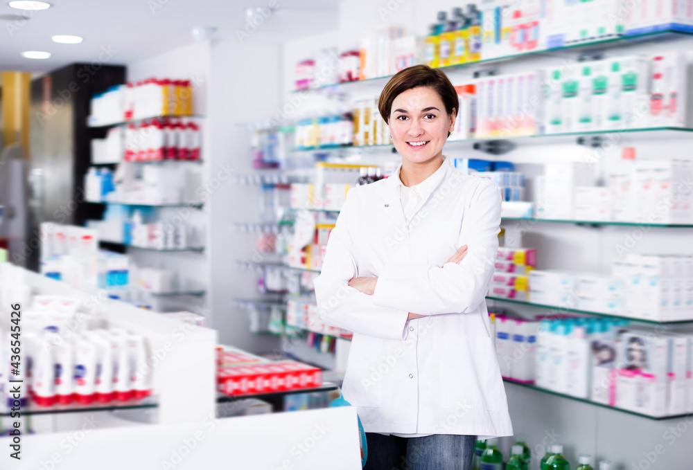 Female pharmacist displaying assortment of products in pharmacy