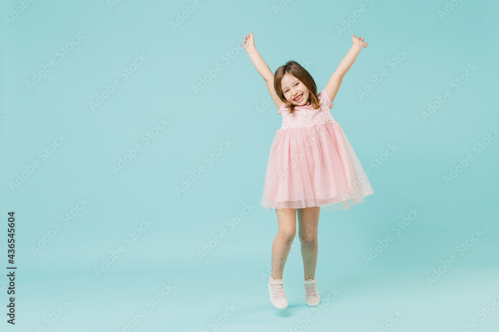 Naklejka premium Full size body length little fun cute kid girl 5-6 years old wears pink dress dancing isolated on pastel blue color background child studio portrait. Mother's Day love family people lifestyle concept.